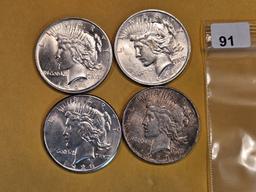 Four mixed Peace silver dollars