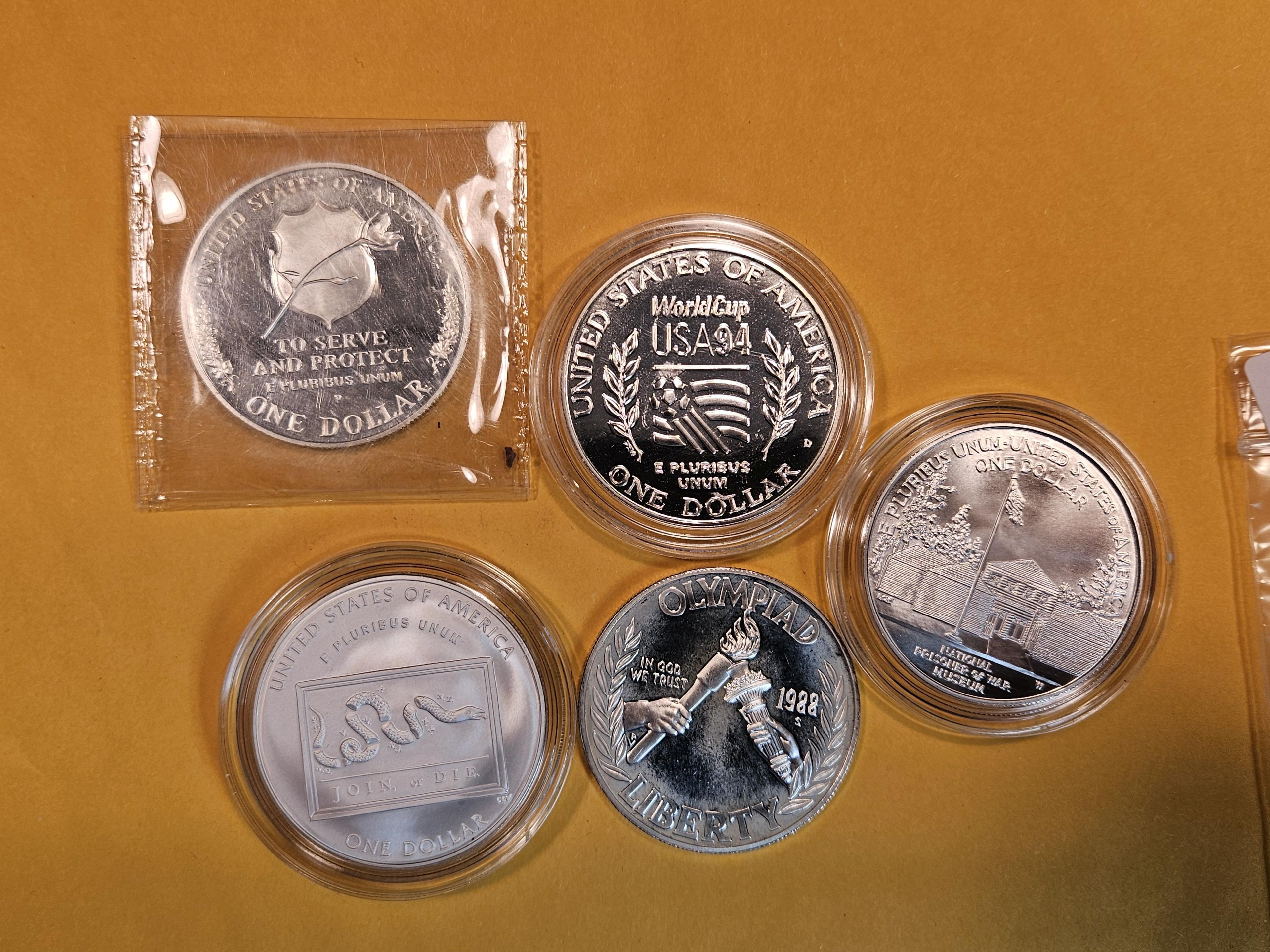 Five mixed Commemorative Silver Dollars