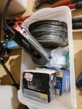 Boxes of assorted screws, metal latch, electric staple gun and a roll of electric fence wire.