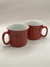 Two red and white ceramic mugs