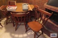 Maple table with three matching chairs and one extra chair, in basement