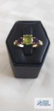 Gold colored ring with one green gemstone and two purple gemstones, marked 18K,...1032 and 104, tota
