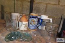 Assorted mugs, antique jars, and antique canning lids