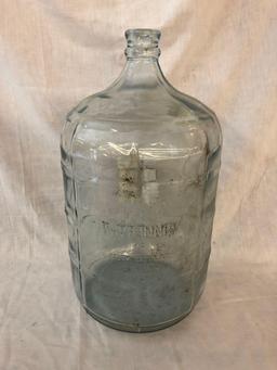 5-gallon glass jug with advertisement