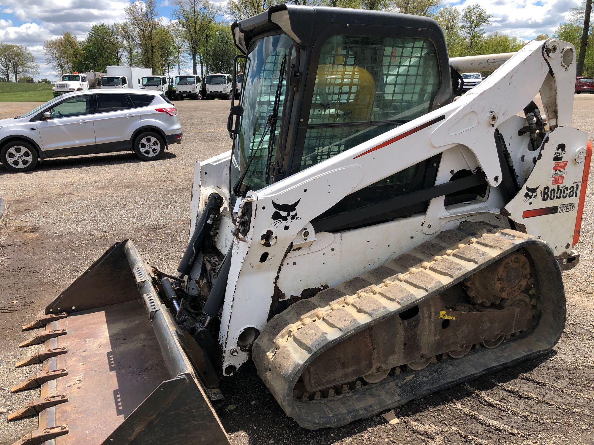 2013 Bobcat T650 with 2 speed, remotes, Bobcat tach quick release, heat & A/C, material bucket