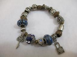 Three Silver Tone Bracelets including two-strand with beads, charms and more, 3 oz