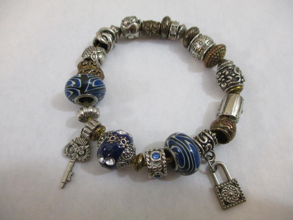Three Silver Tone Bracelets including two-strand with beads, charms and more, 3 oz