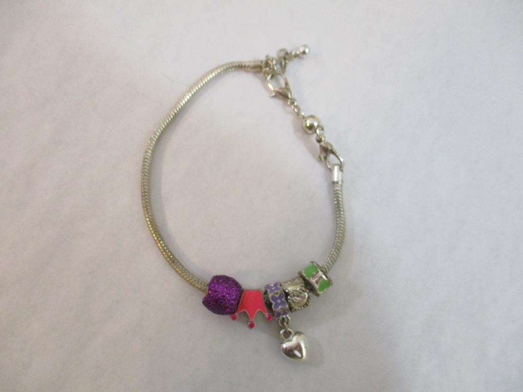 Three Silver Tone Bracelets including two-strand with beads, charms and more, 3 oz