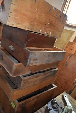 STACK OF WOODEN CRATES AND DRAWERS WITH WOOD AGAINST WALL