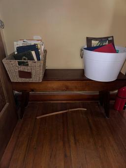 wooden bench and two baskets full of various books, including Bibles and old magazines