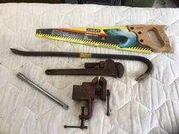 Stanley handsaw, wrecking bar, pipe wrench, vice, and half inch extension