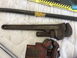 Stanley handsaw, wrecking bar, pipe wrench, vice, and half inch extension