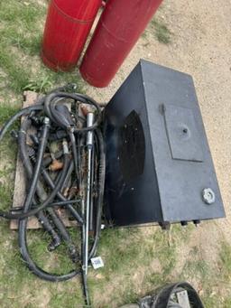 Hydraulic tank with mixed hoses and fittings.