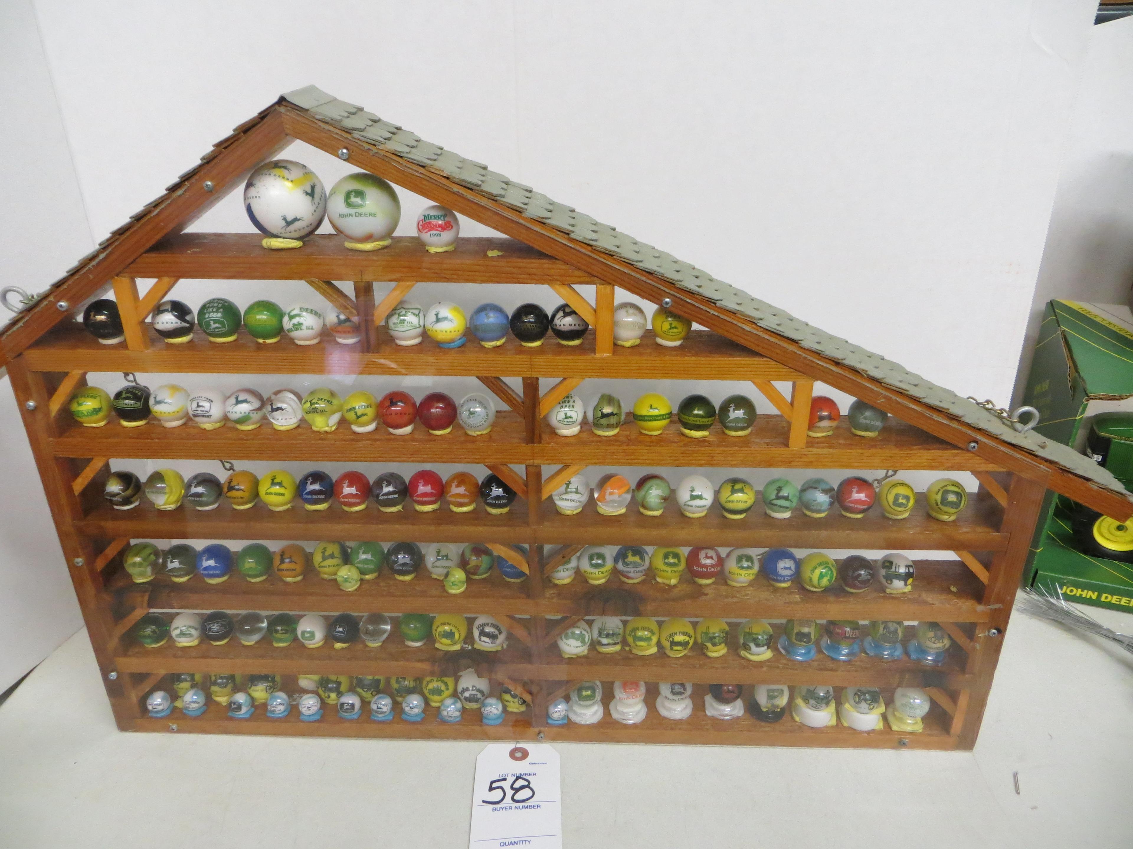 Large collection of John Deere marbles of all sizes in a barn display case