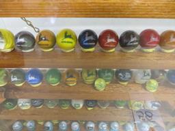Large collection of John Deere marbles of all sizes in a barn display case
