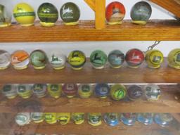 Large collection of John Deere marbles of all sizes in a barn display case