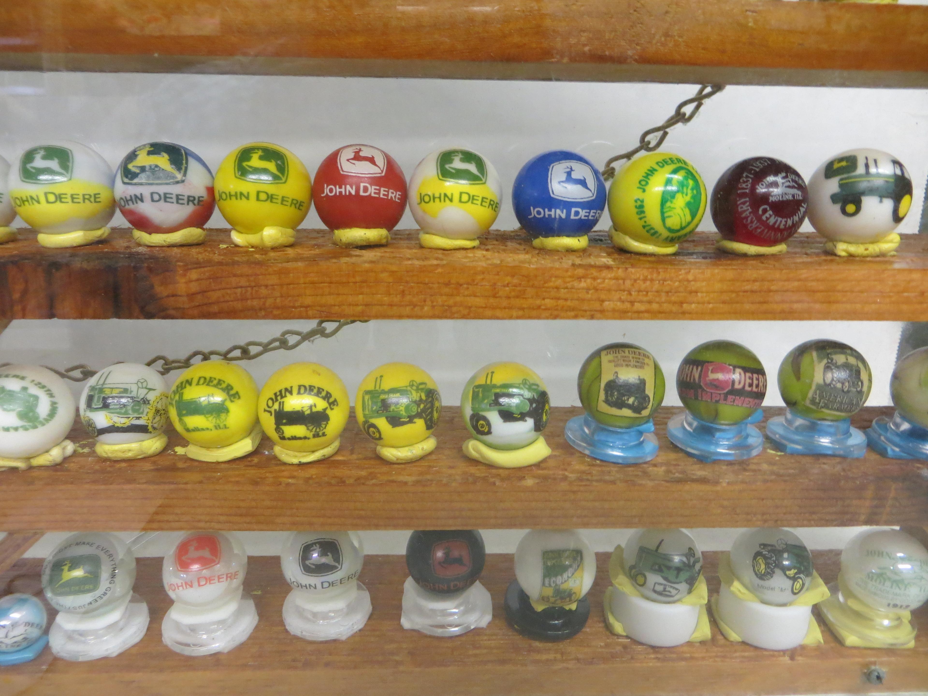 Large collection of John Deere marbles of all sizes in a barn display case
