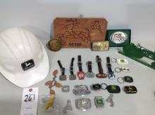 assortment of John Deere fobs, hard hat, belt buckles, money clip, key chains