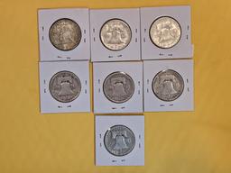 Seven mixed silver Franklin Half Dollars