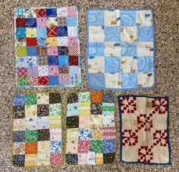 Five small quilted doll blankets