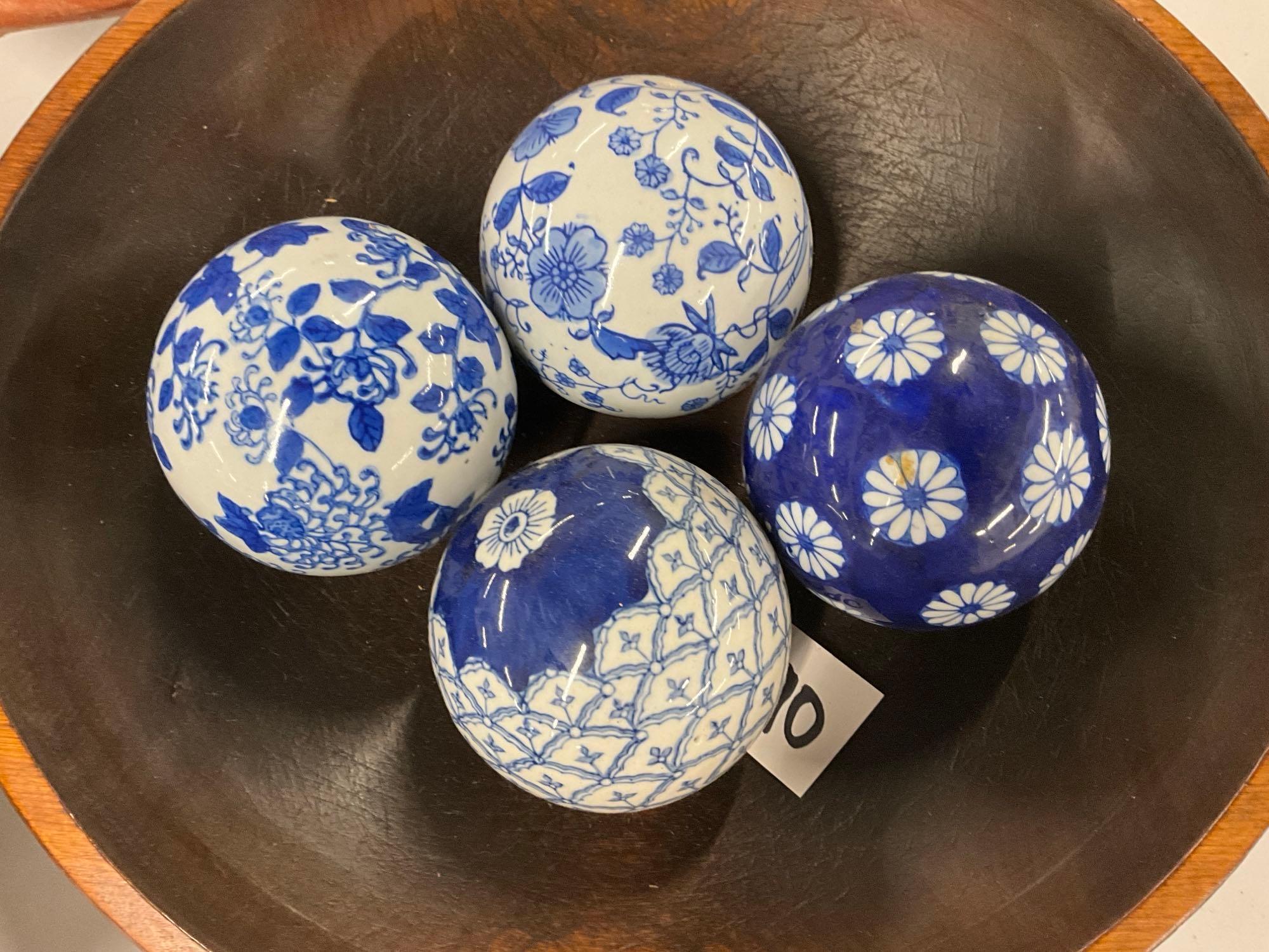 Pair of wooden bowls with blue and white pattern glass balls and pottery sun face