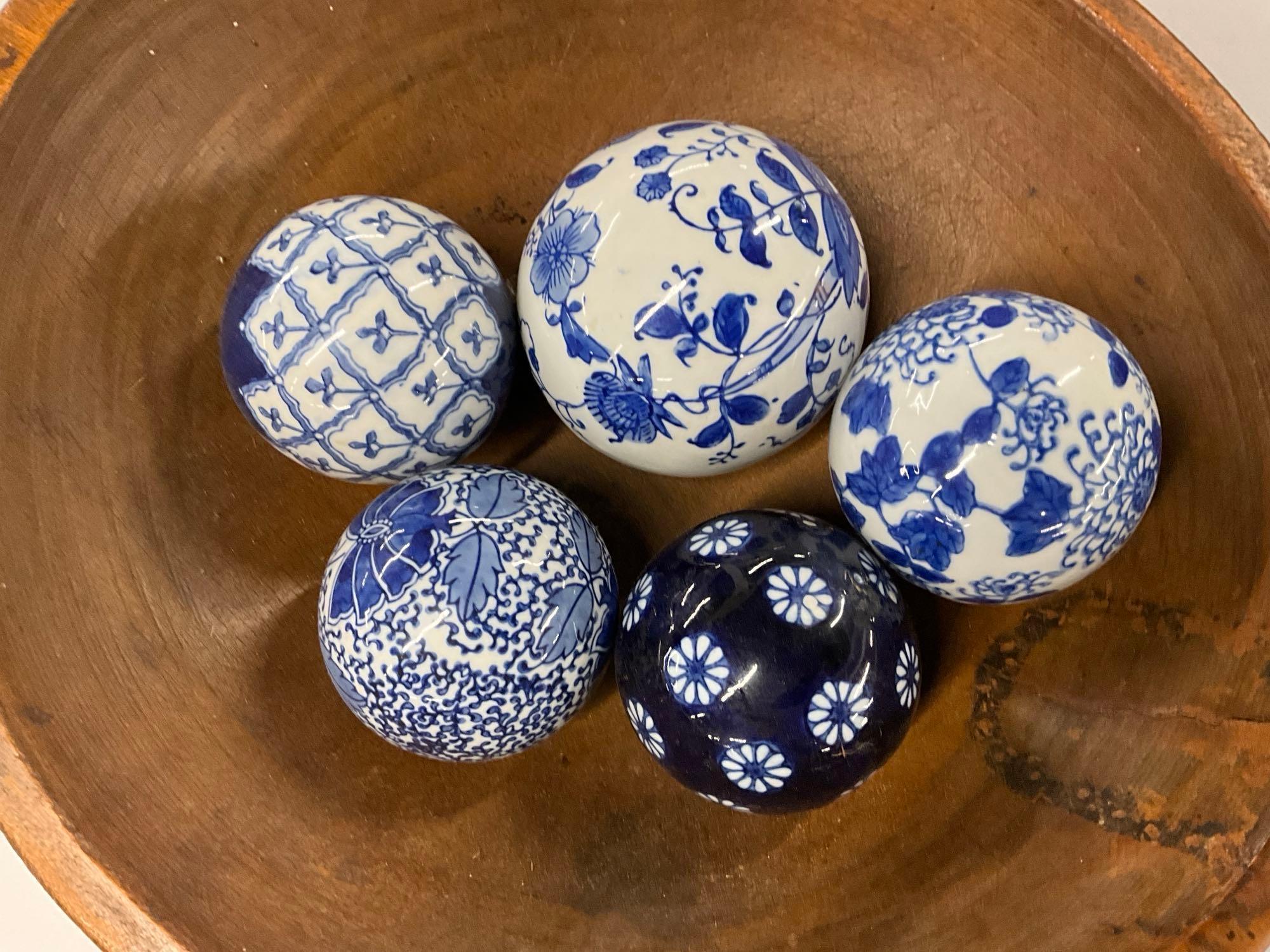 Pair of wooden bowls with blue and white pattern glass balls and pottery sun face