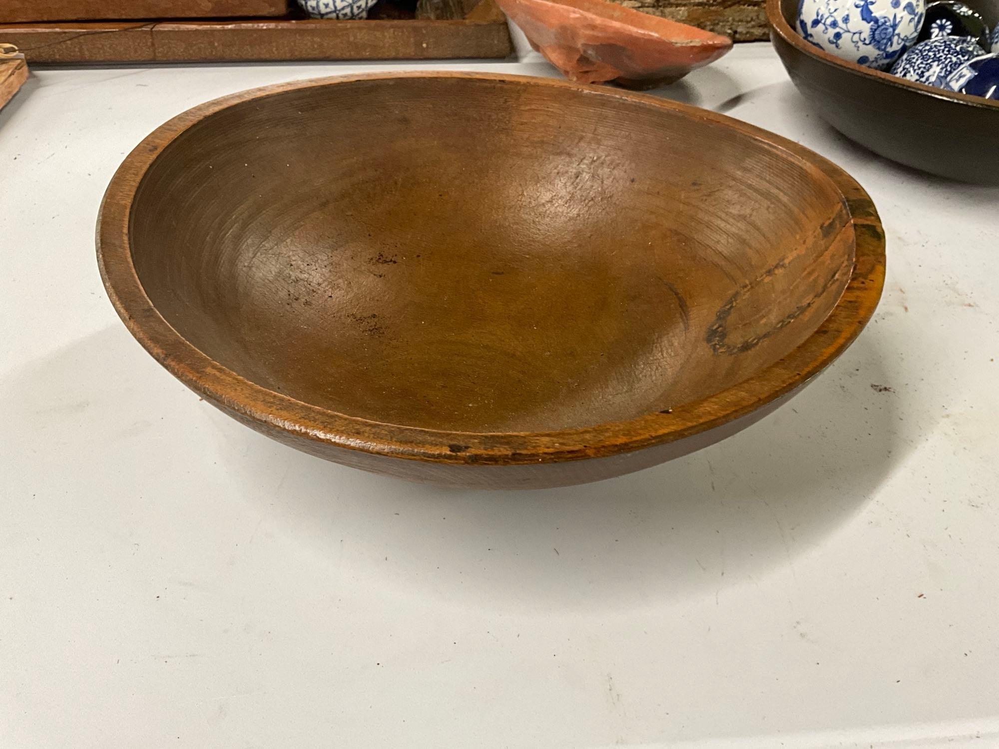 Pair of wooden bowls with blue and white pattern glass balls and pottery sun face