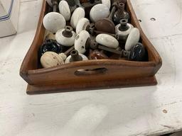Wooden tray of vintage porcelain and metal door knobs