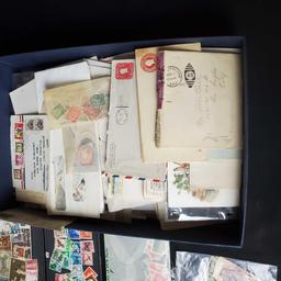 box of stamps and stamped envelopes from around the world