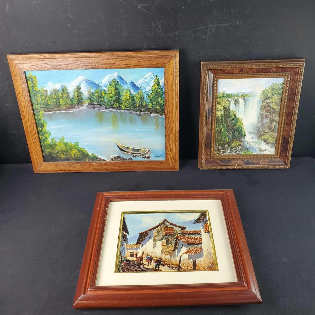 3 Framed oil/canvas artwork pieces with signatures Canoe on lake waterfalls village houses/people