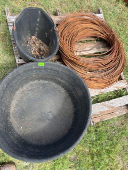 Feed bucket, mineral feeder, and a roll of heavy ga wire.