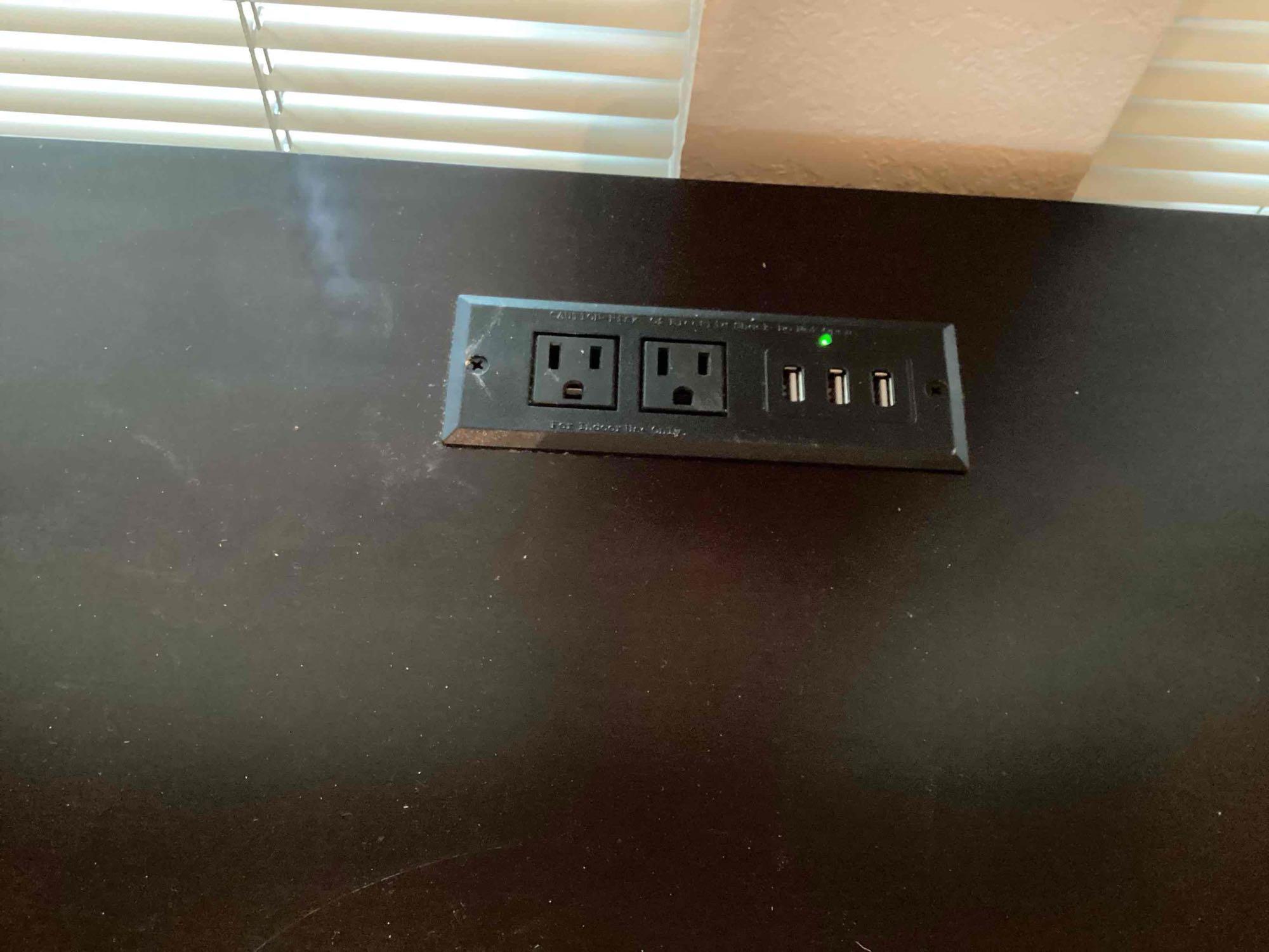 wooden black desk with outlet