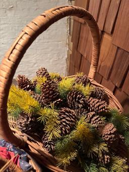 Several woven baskets, greenery with pine cones, duck pillow and more