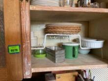 Whole bottom shelf, storage shelf with plastic dishes and Corning ware, small aluminum loaf pan, ice