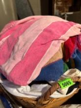 Woven basket with towels and sheets, size unknown