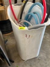 white trash can with misc hoses