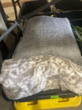 tub of decorative throw pillows; blanket