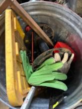Metal trashcan with a lid to a tote gloves, empty wire spool and other miscellaneous items
