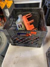 Black milk crate with Motor oil, ratchet strap, and other items