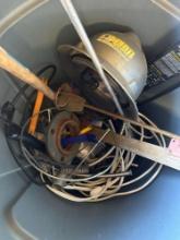 Trash can with hardhat, extension cord, wire brush, and other items