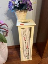 Toilet paper holder and flower arrangement in vase