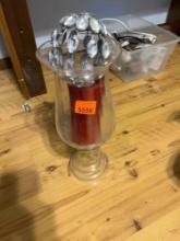 Glass candle holder with candle and misc item