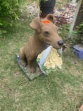 Outdoor dog statue holding a basket