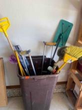 Trash can with contents which include brooms, crutches, fan blade cleaner and more