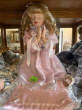 Praying porcelain doll with blanket