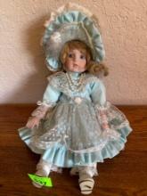 Porcelain doll and blue with pearl like necklace