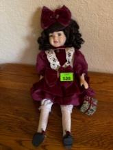 Porcelain doll and maroon dress with present