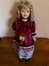 Porcelain doll and maroon dress with white lace, black shoes