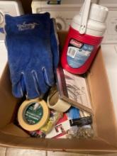 Box of misc items, Coleman cooler jug, weld a beast gloves, masking tape, 2 adjustable harps, and