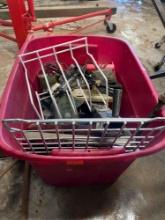 Red tote with black hose, tape, racks, metal flower, tire iron and much more